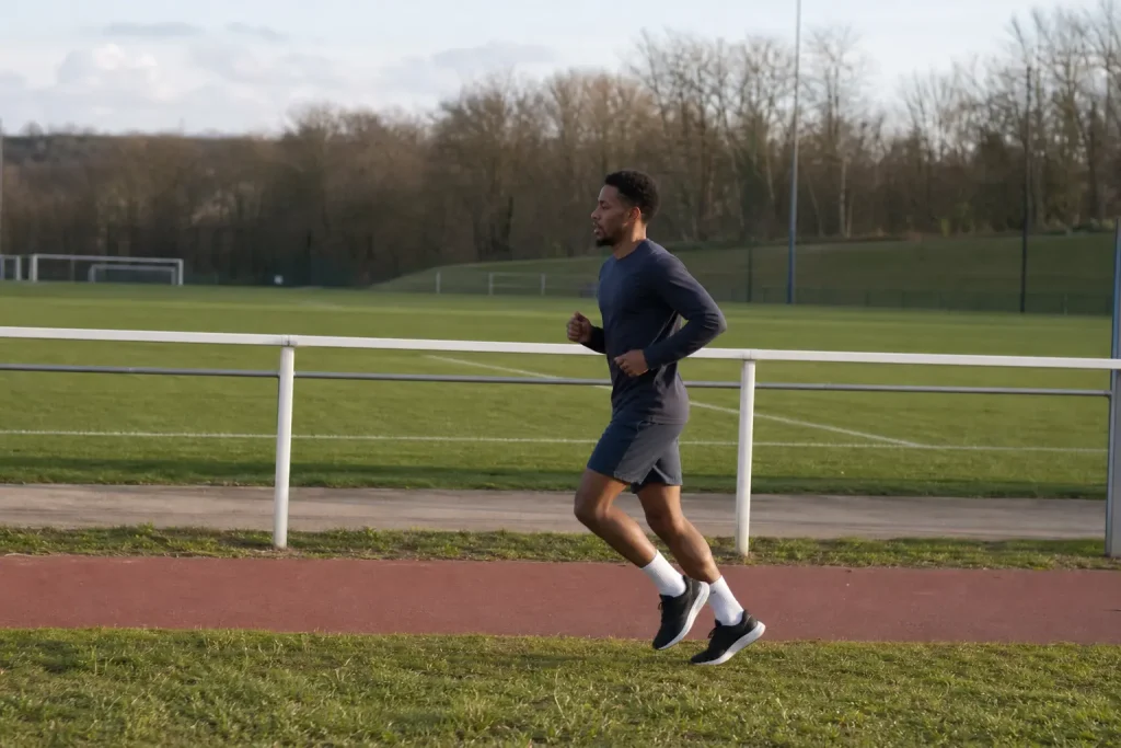 En löpare joggar ensam på träningsplanen inför MFF Champions League-kval en sen eftermiddag.