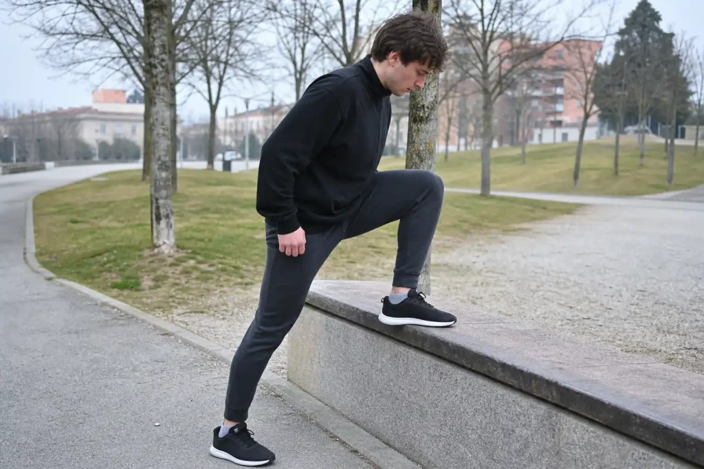 Person gör step-ups på en stenkant utomhus, en av 9 benövningar hemma som gör dig redo för vintern