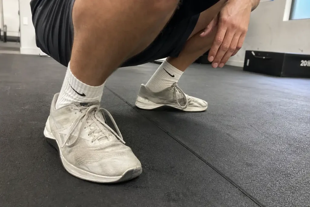 Person i djup knäböj på gymmatta, en av 9 benövningar hemma som gör dig redo för vintern.